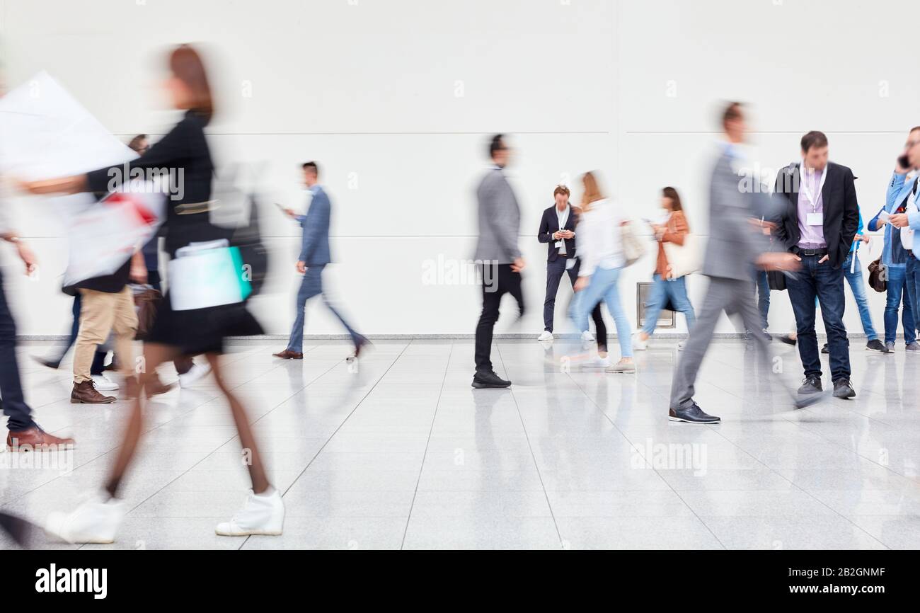 Many anonymous blurred people go to trade fair or congress Stock Photo