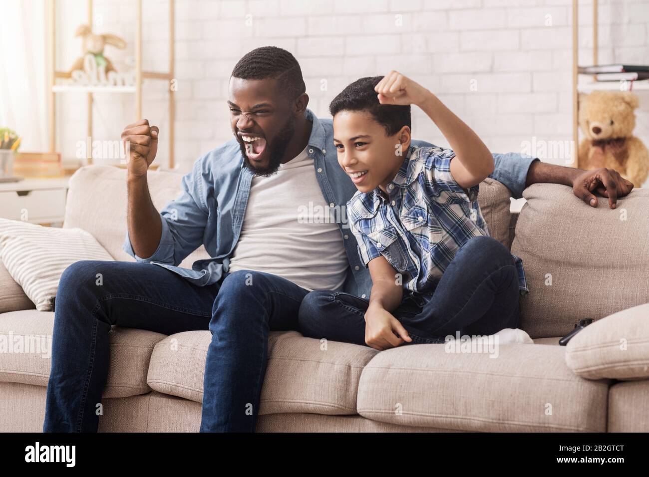 Father teen son watching tv hi-res stock photography and images - Alamy