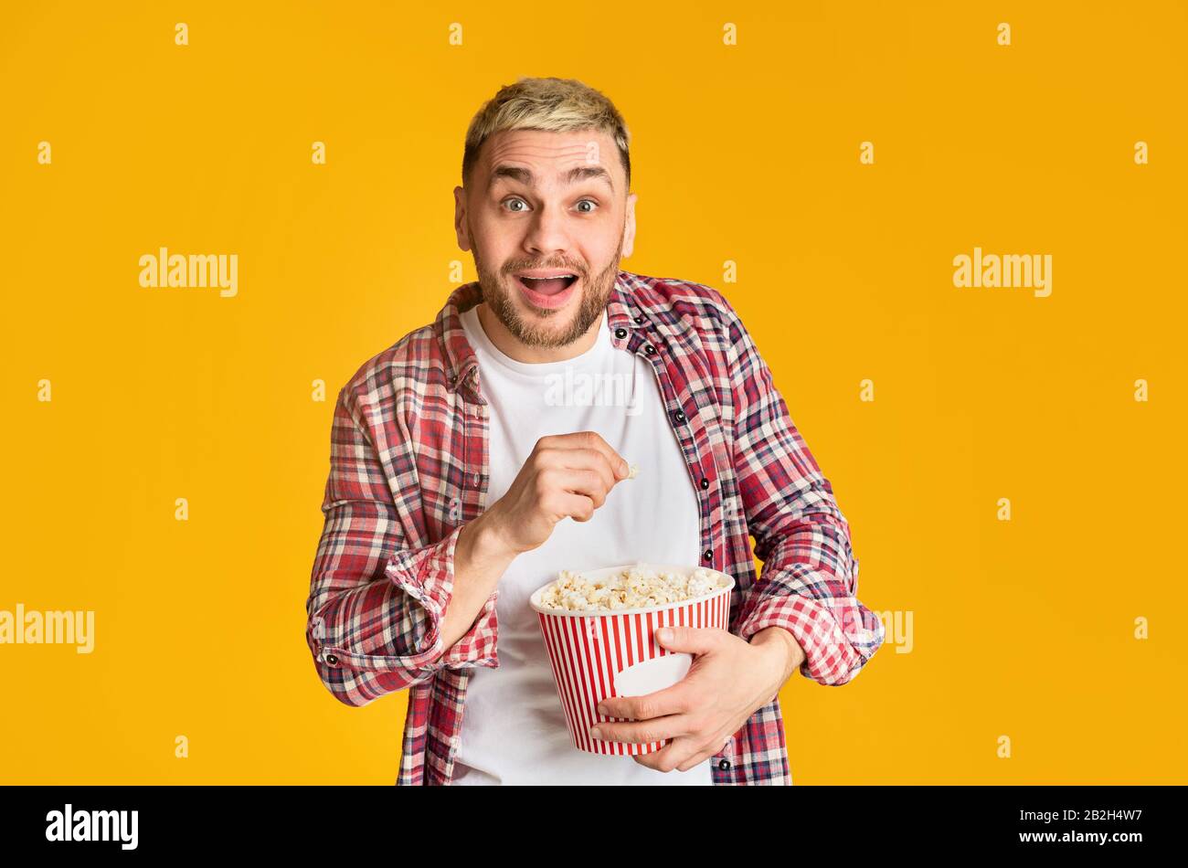Guy watching movie emotionally and eating popcorn Stock Photo Alamy