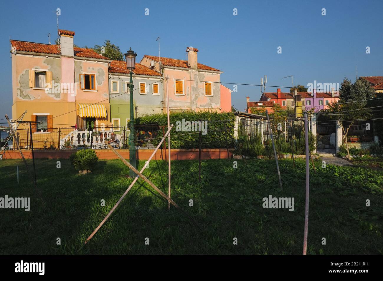 A park and back yards of colourful houses on Calle Malea, the life and architecture of Burano, Venice in early morning light Stock Photo