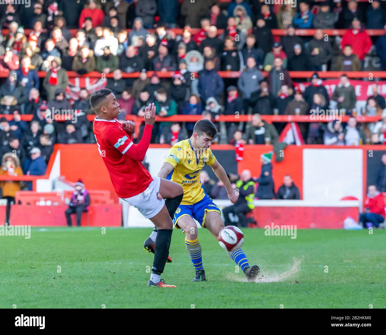 Warrington's Tom Warren kicks the ball past one of the FCUM defenders Stock Photo