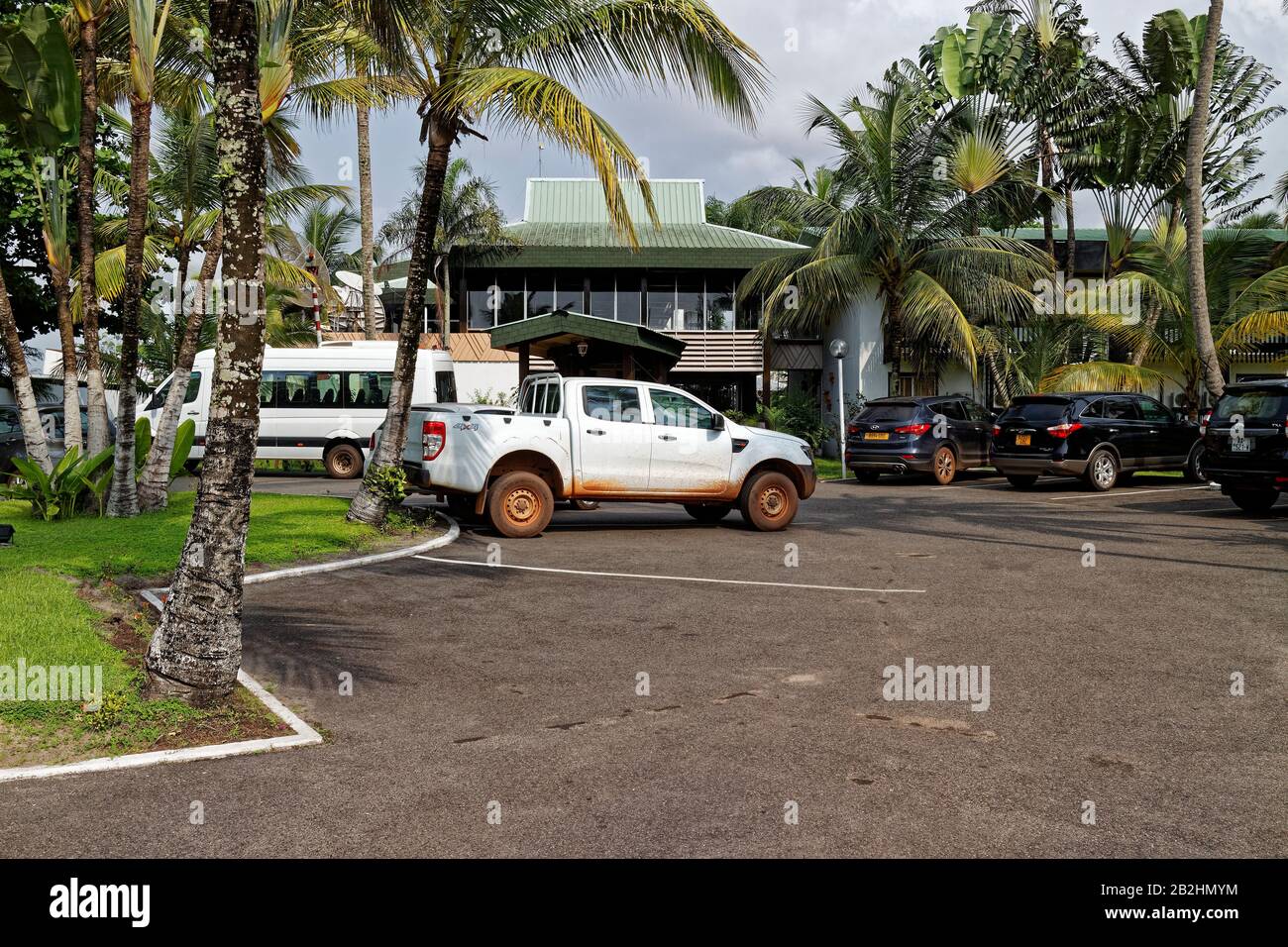 Parked trucks and SUV's in front of the Hotel entrance of the The Meridien  Mandji early in the morning in Port Gentil Stock Photo - Alamy