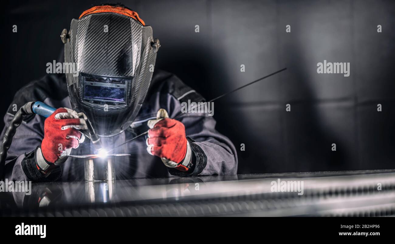 Welder industrial worker welding with argon machine. Stock Photo