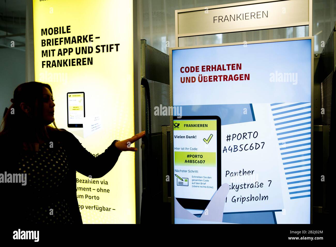 Berlin, Germany. 03rd Mar, 2020. At the press conference of DHL Post & Paket  Deutschland, a product manager presents the franking of parcels with a  mobile phone. In a press conference, the