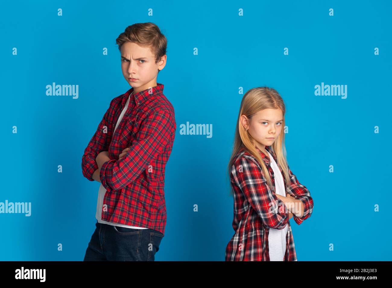 Siblings Conflicts. Offended Brother And Sister Ignoring Each Other After Quarrel Stock Photo