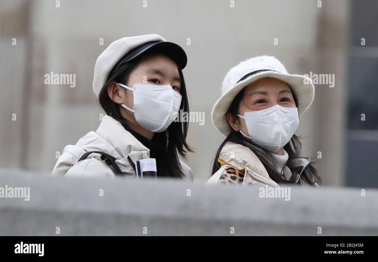 Two women walk through London's Trafalgar Square wearing protective facemasks on the day that Heath Secretary Matt Hancock said that the number of people diagnosed with coronavirus in the UK has risen to 51. Stock Photo