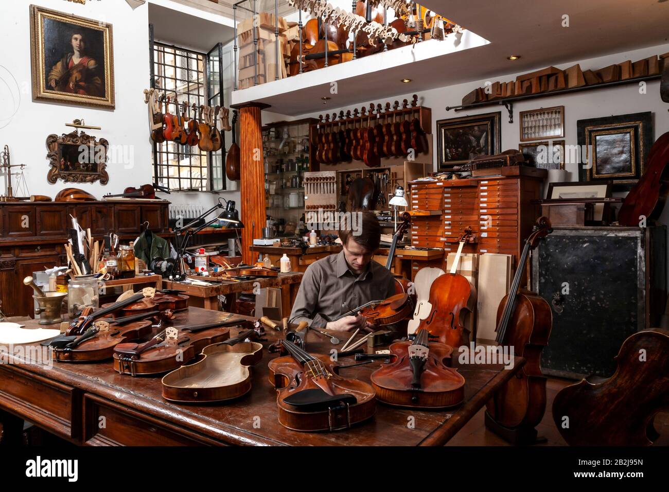 Luthier violin maker working on making a violin in a workshop Stock Photo -  Alamy