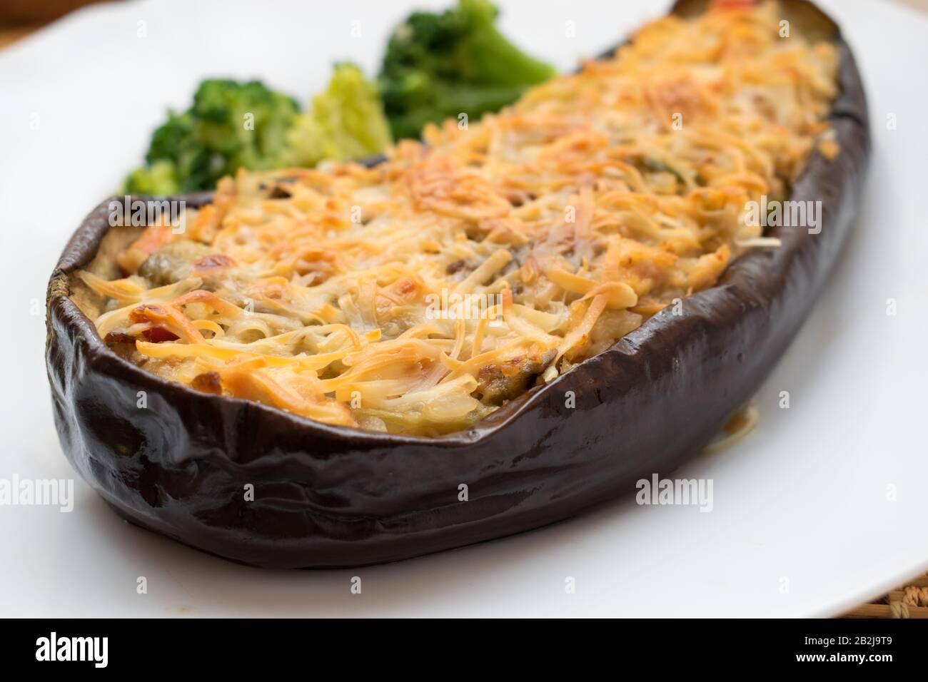 close-up of eggplant stuffed with grated cheese on top Stock Photo