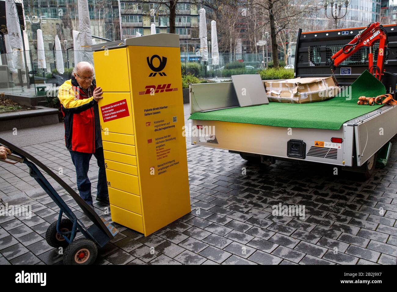 Berlin, Germany. 03rd Mar, 2020. Employees of a transport company load part  of a packing station of Deutsche Post and DHL after a press conference. In  a press conference, the company presented