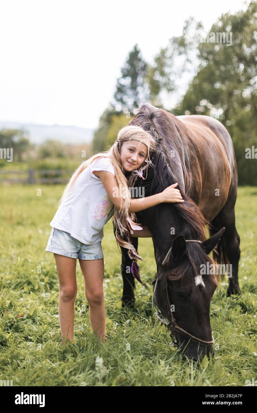 Ranch, countryside, nature. Lovely girl with horse. Pretty girl with blond  long hair touching and petting beautiful horse outdoor at nature Stock  Photo - Alamy