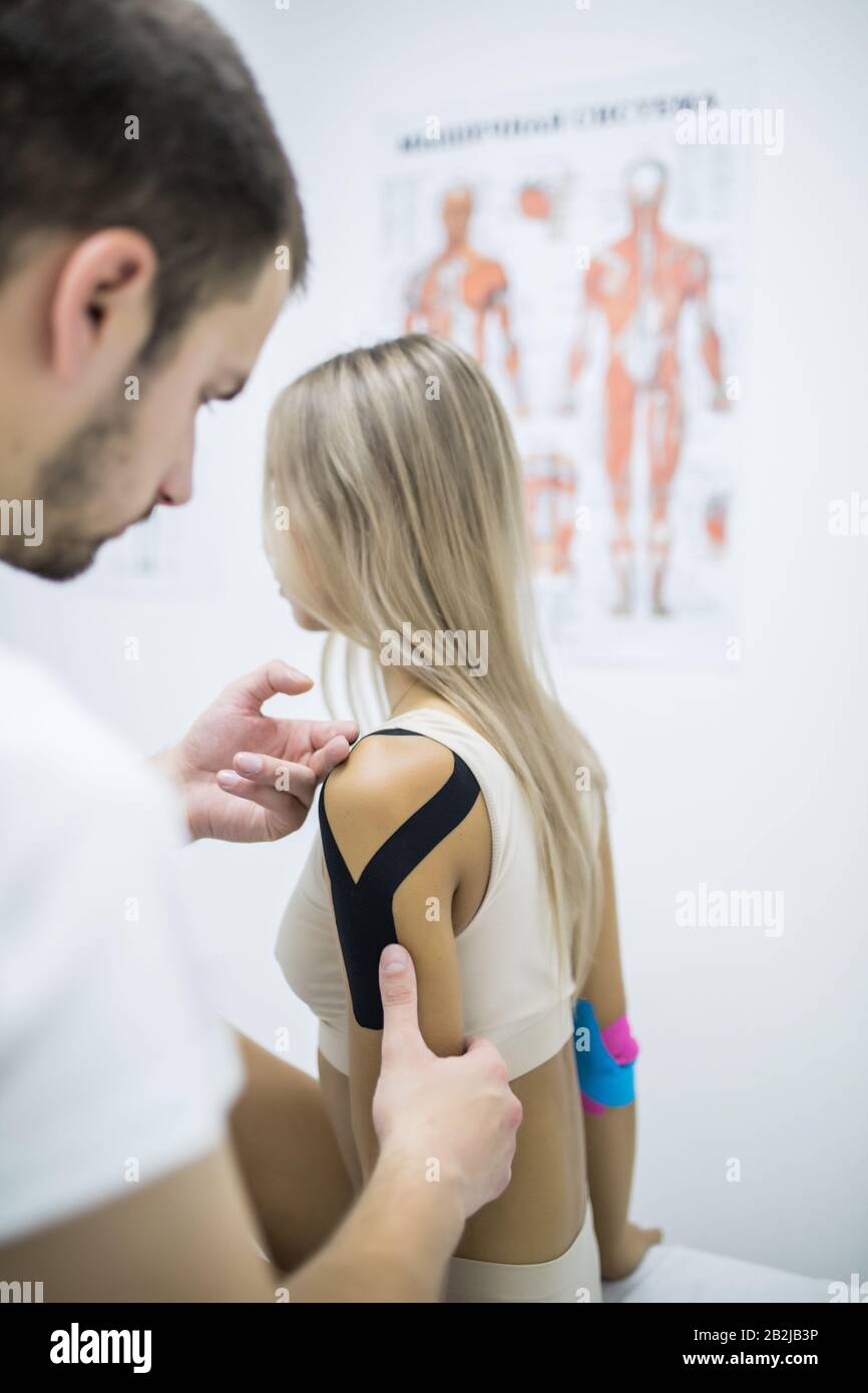 Kinesiology taping treatment with blue tape on female injured arm. Sports injury kinesio treatment Stock Photo - Alamy