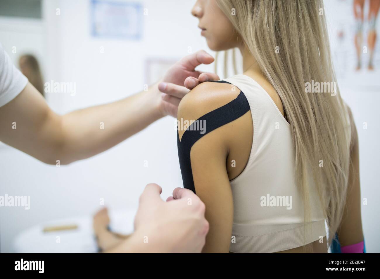 Kinesiology taping treatment with blue tape on female injured arm. Sports injury kinesio treatment Stock Photo - Alamy