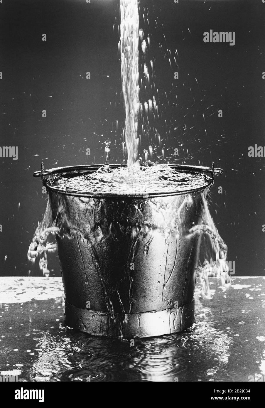Water pouring into a bucket (b&w) Stock Photo