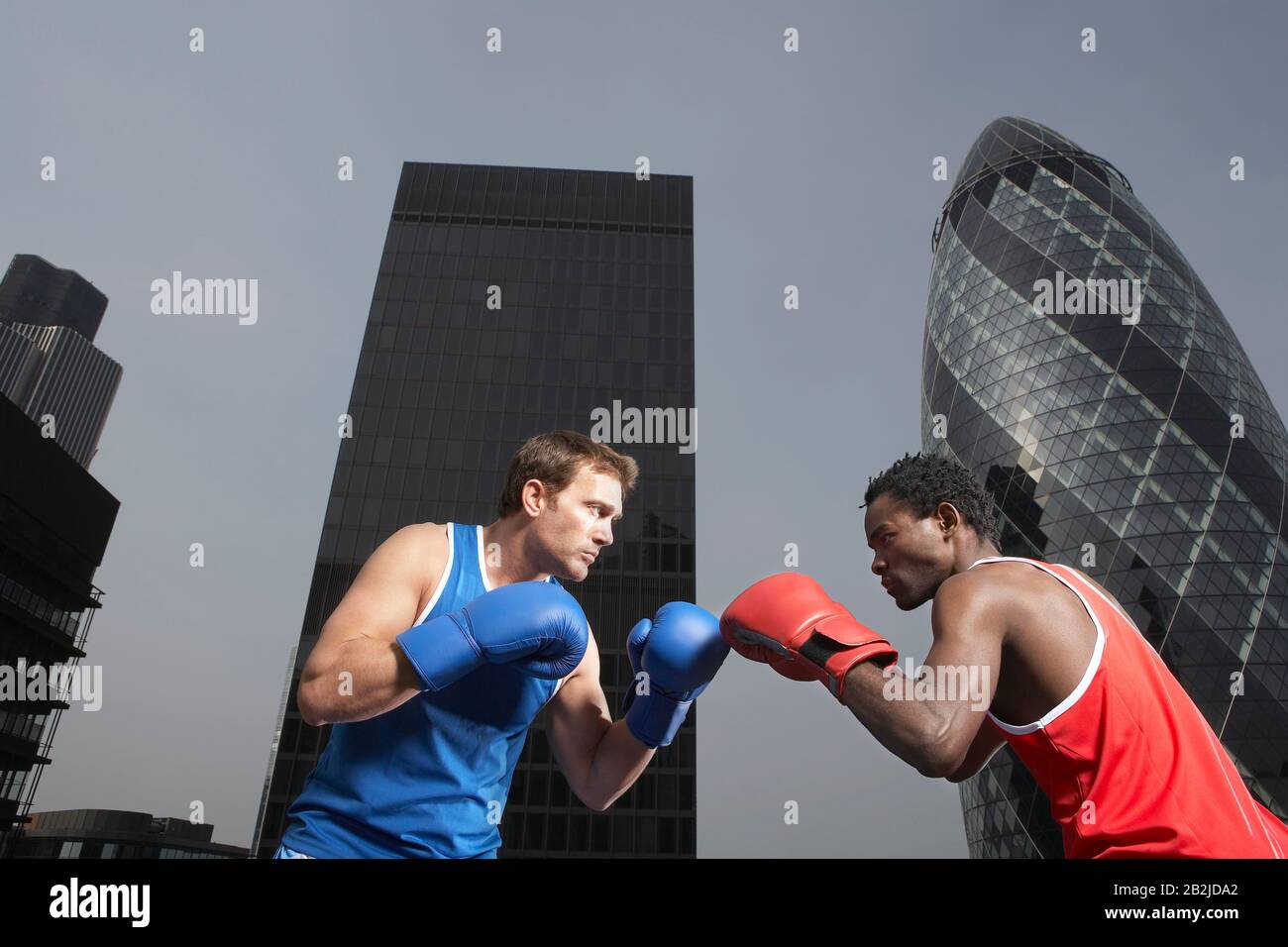 Two boxers punching amongst downtown buildings low angle view London