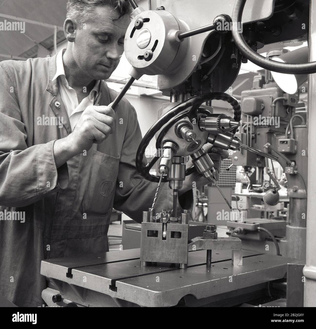 1950s, historical, precision engineering, a machinist working with a mutli-drill lathe machinery, in the aviation industry, England, UK. Requiring precision work, a machinist is a skilled tradesman in the use of drilling machines, grinders and lathes. Stock Photo