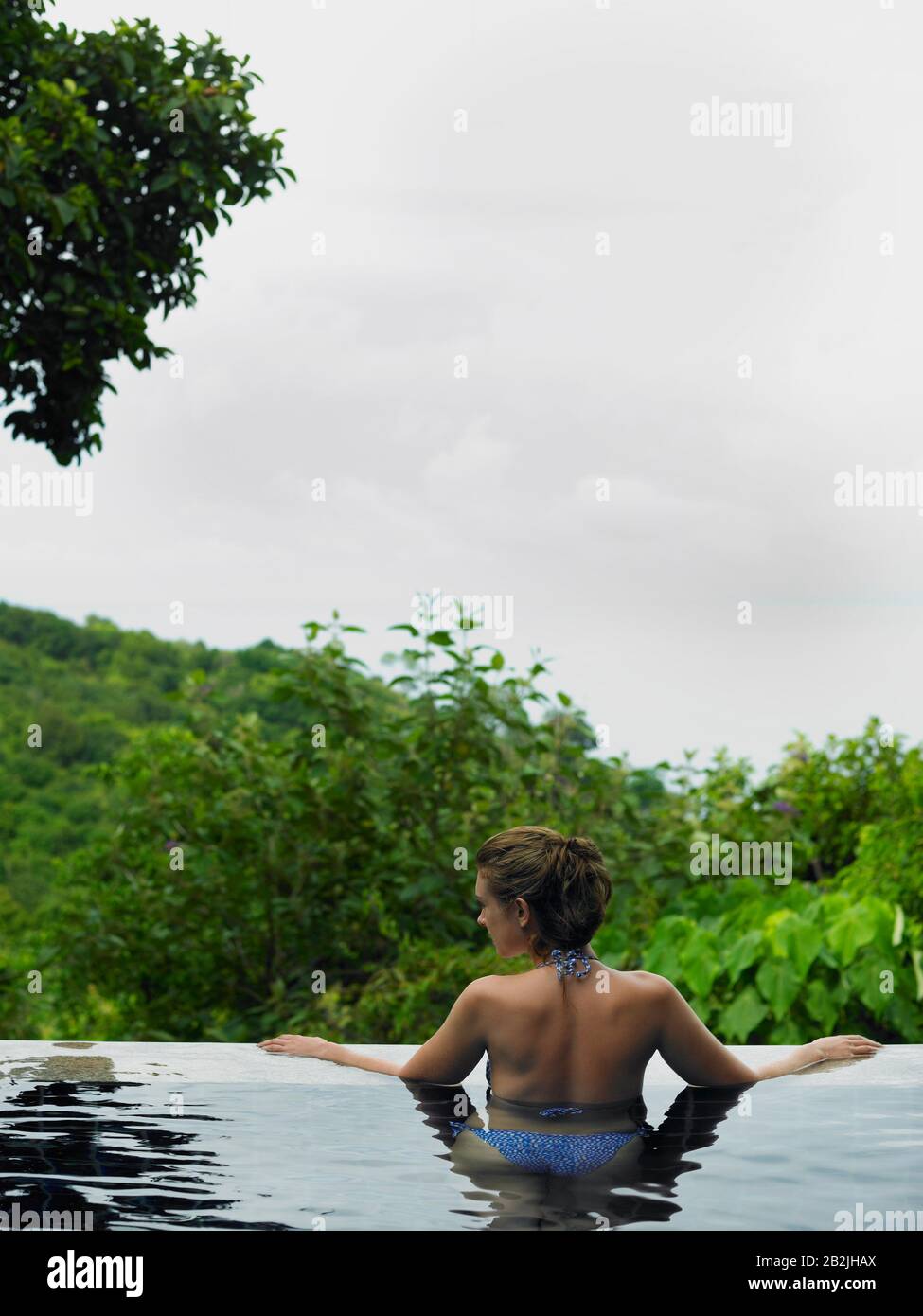 Woman Wading in an Infinity Pool Stock Photo
