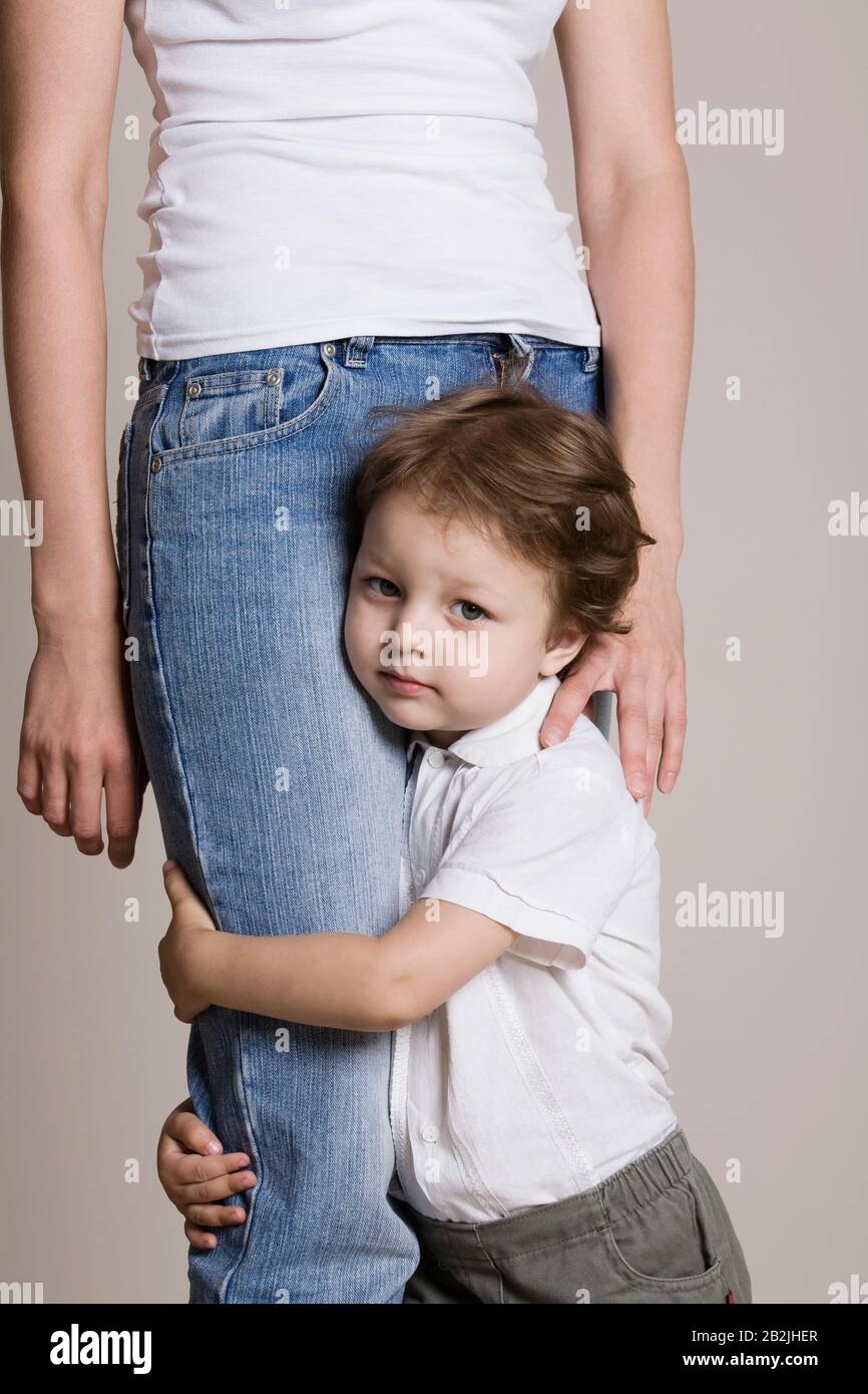 Boy hugging his mothers leg Stock Photo Alamy