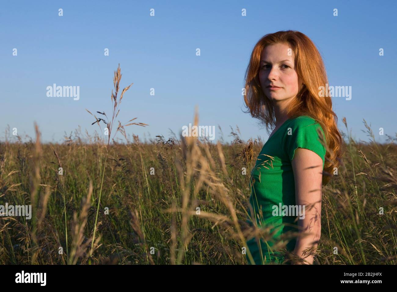 Young Woman Standing in a Field of Tall Grass Stock Photo - Alamy