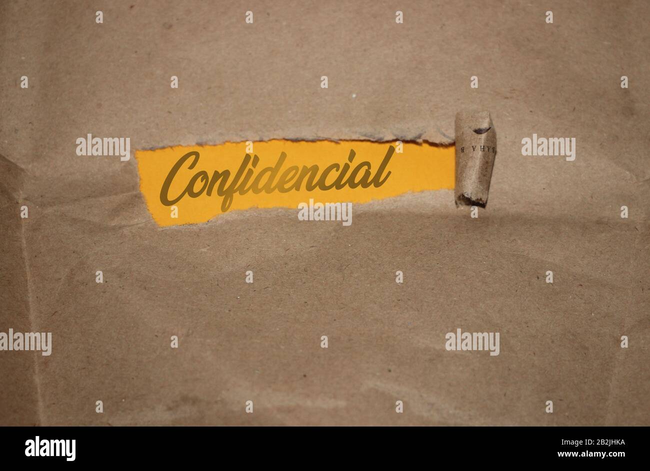 The word confidential appearing behind torn brown paper. Business concept Stock Photo