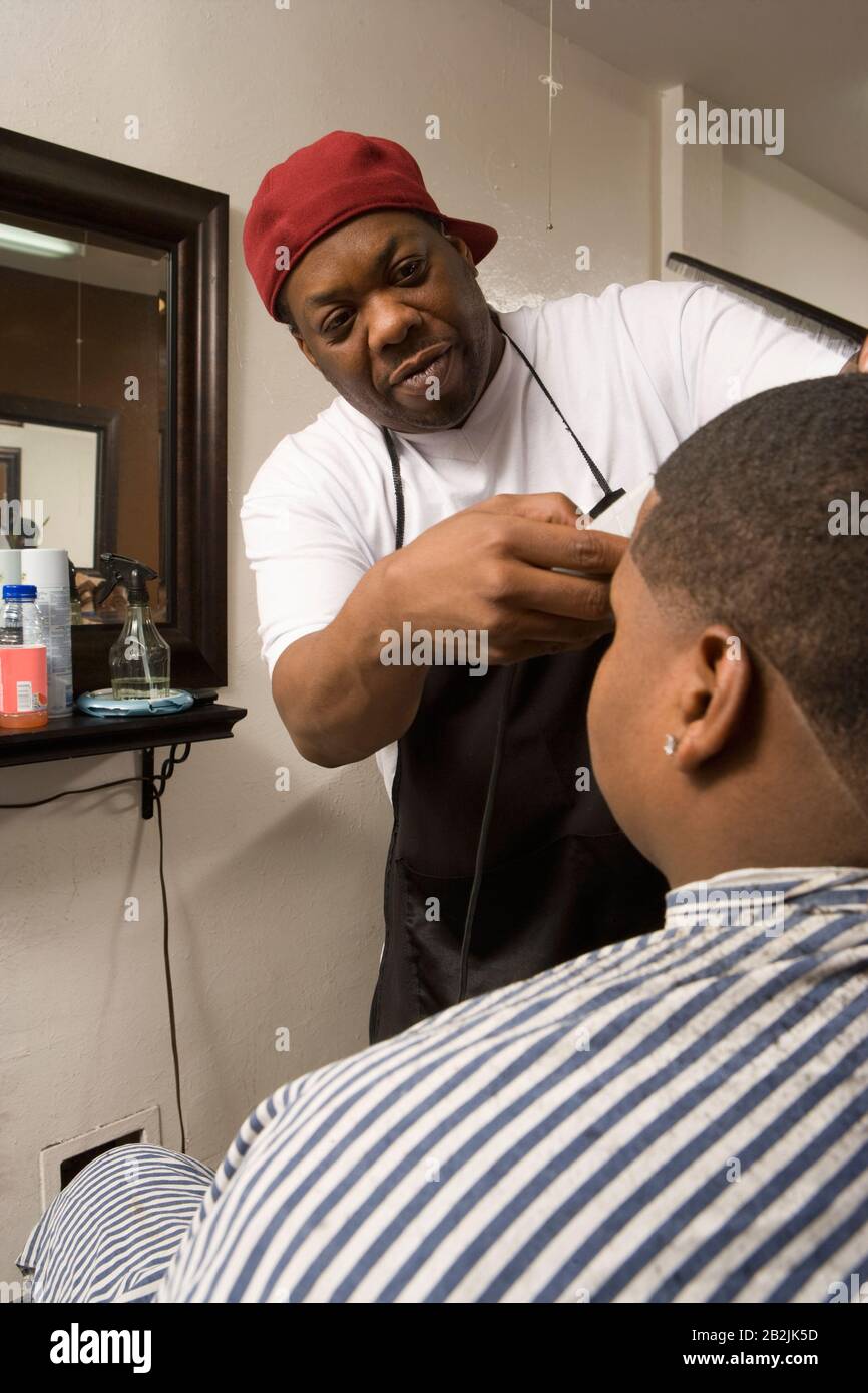 Boy with head being shaved in the barbers Stock Photo