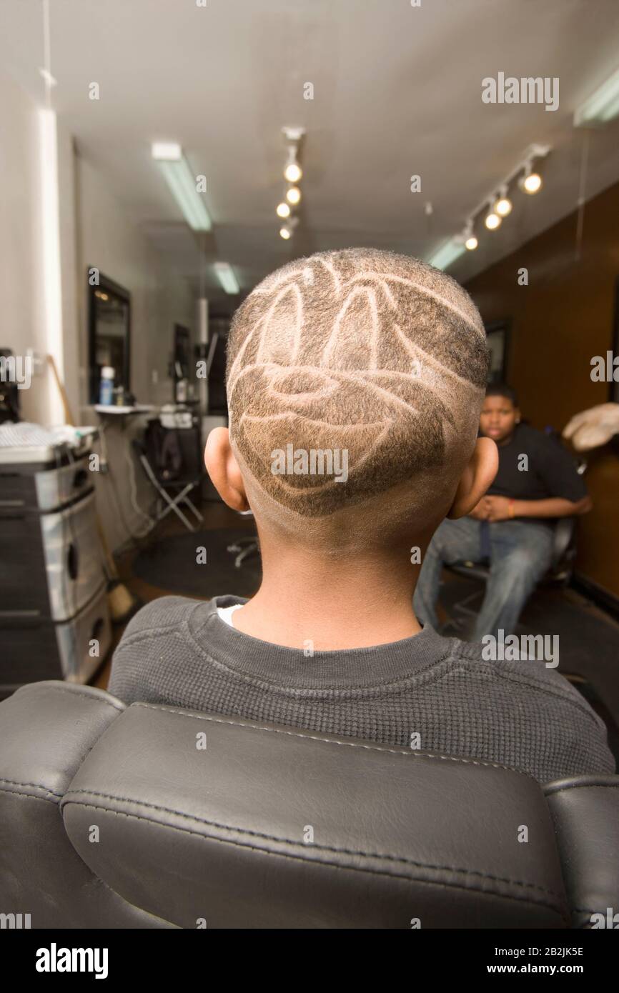 Young boy with shaven head in barbers Stock Photo