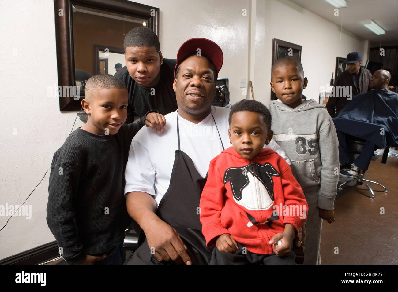 The barbers with his young sons in the barbers Stock Photo Alamy