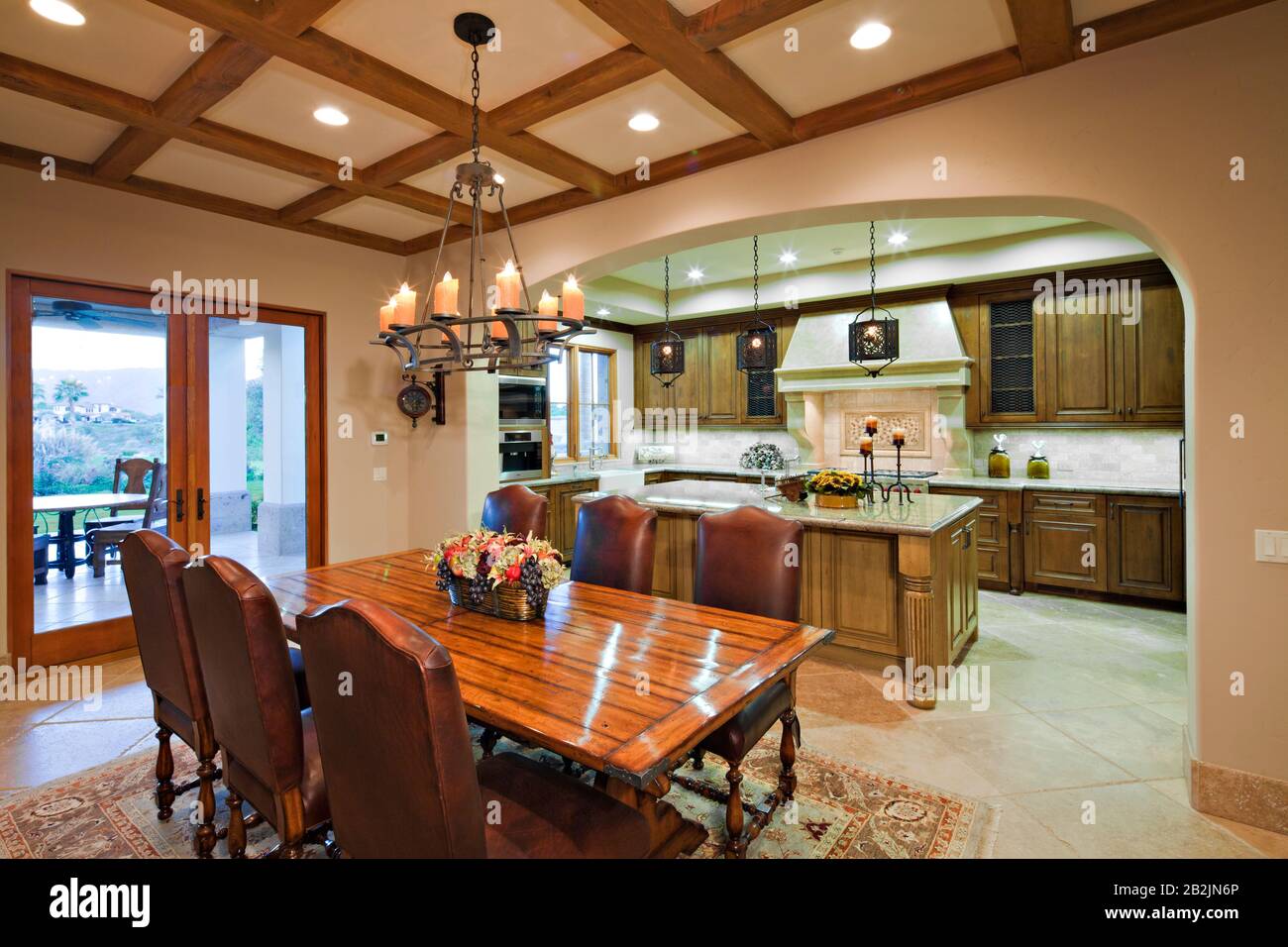 Dining table near kitchen in luxury mansion Stock Photo - Alamy
