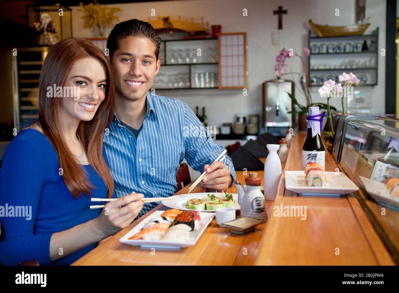 Portrait of young couple eating Japanese cuisine in restaurant Stock Photo