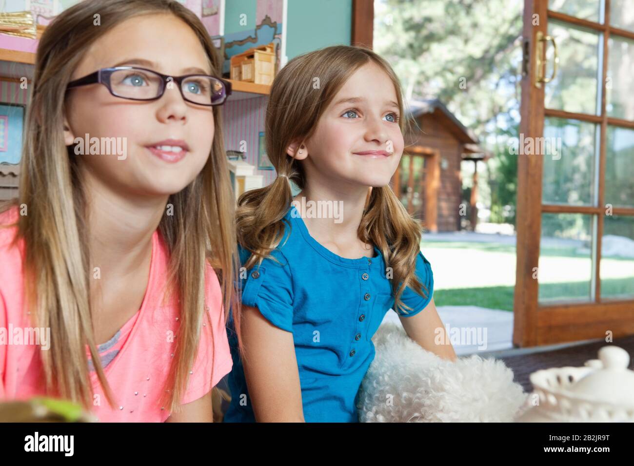 Two young sisters watching television Stock Photo