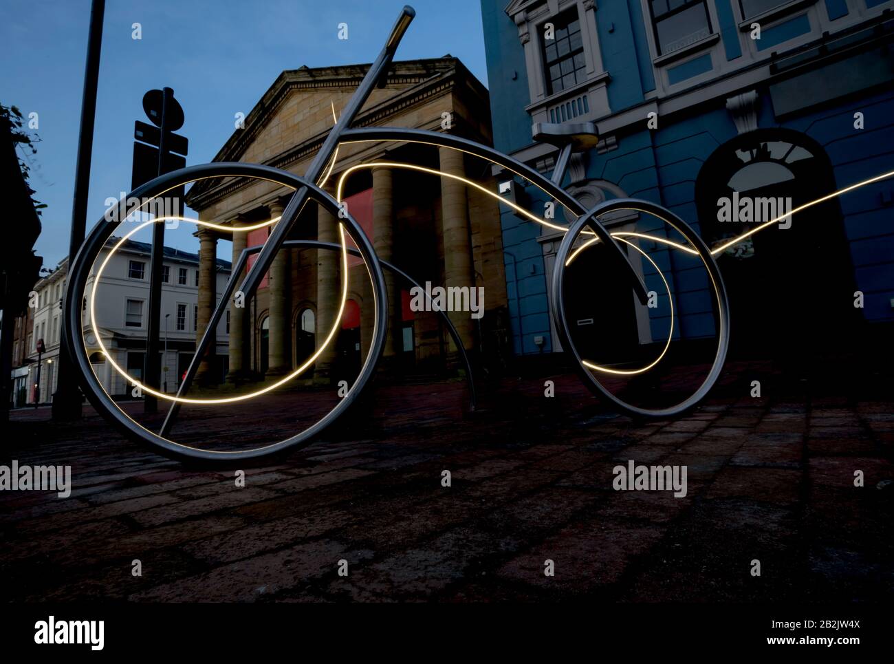 Bike rack at night in the city, energized by speed light Stock Photo