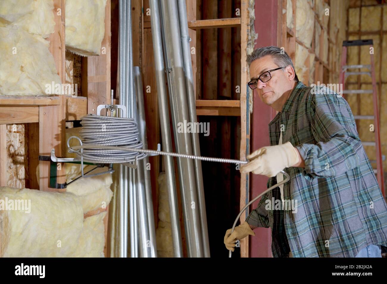 Construction worker pulling iron cable Stock Photo Alamy