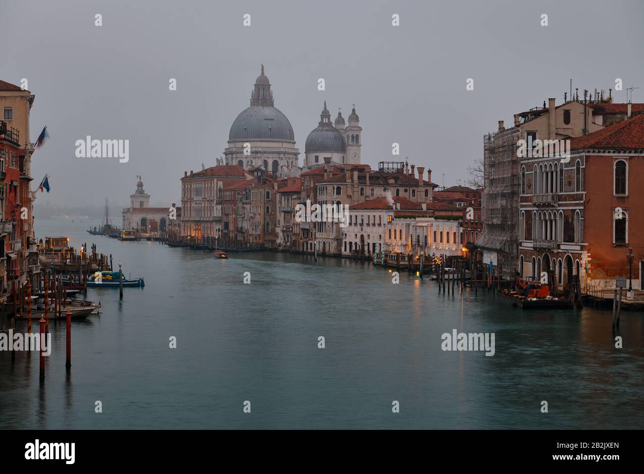 Venice, Italy - February 17 2020 : View of the Grand Canal of Venice Italy and the Basilica Santa Maria della Salute on morning fog Stock Photo