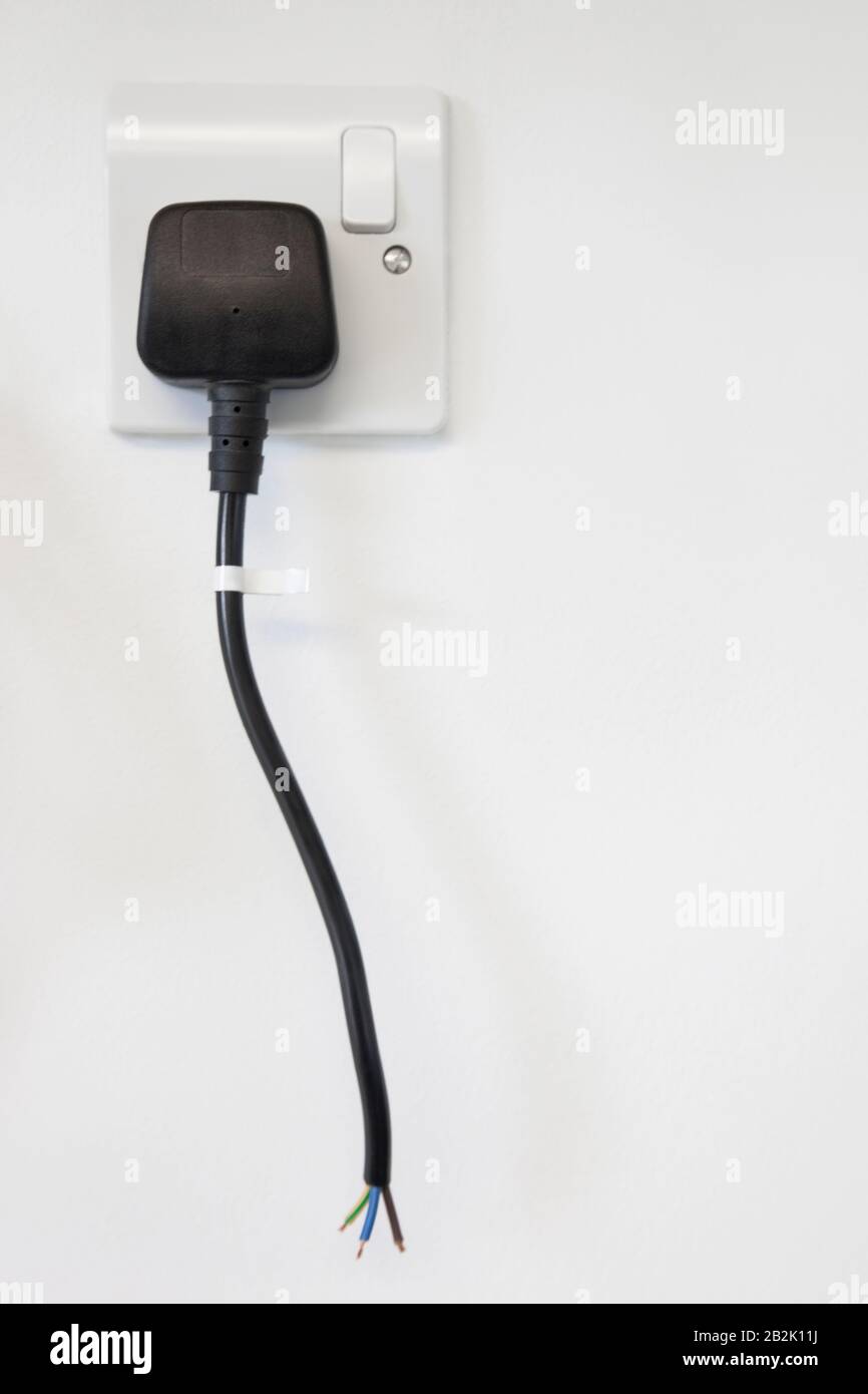 Frayed electrical cord with outlet attached on white wall Stock Photo -  Alamy