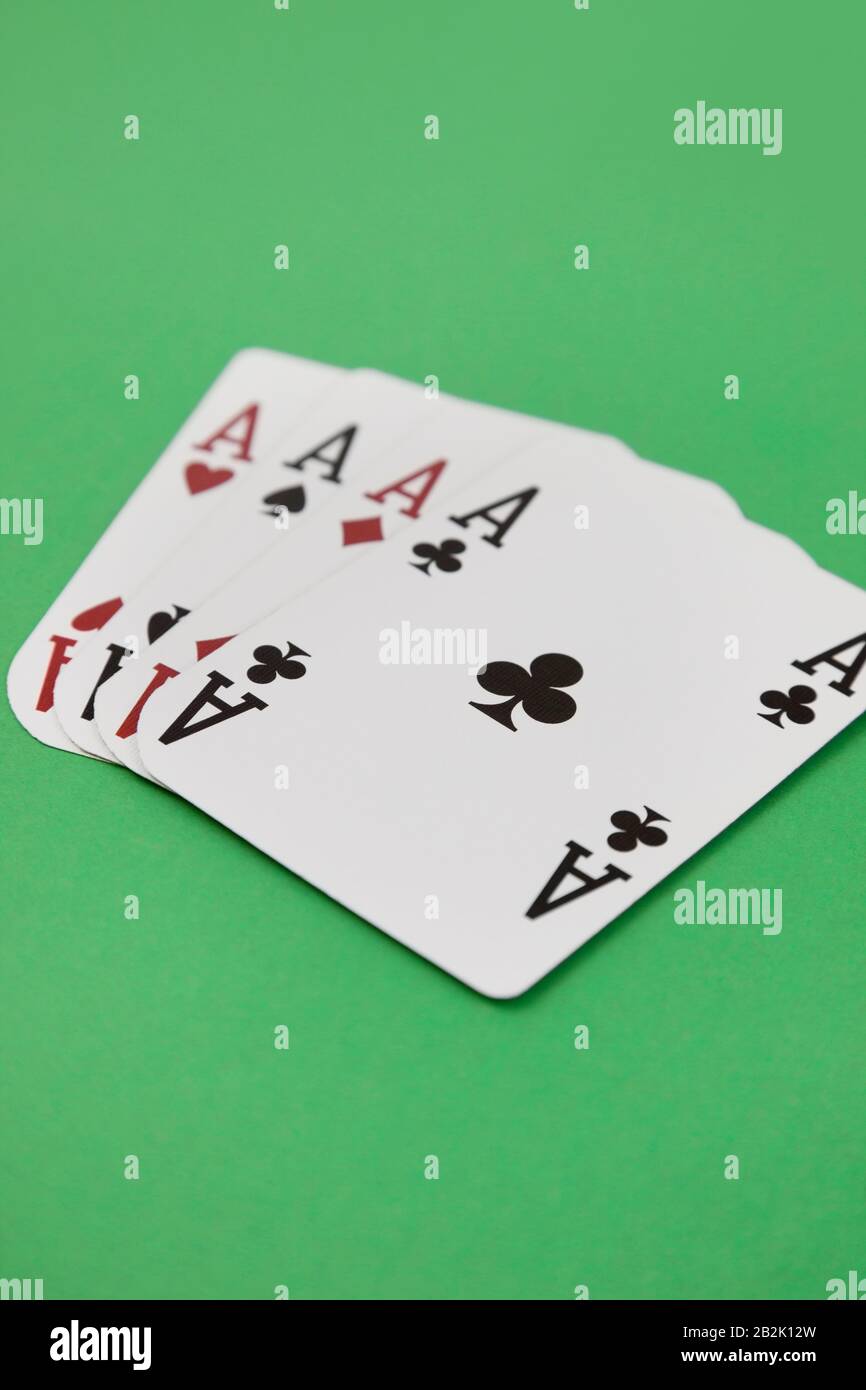 Four aces playing cards over green surface Stock Photo