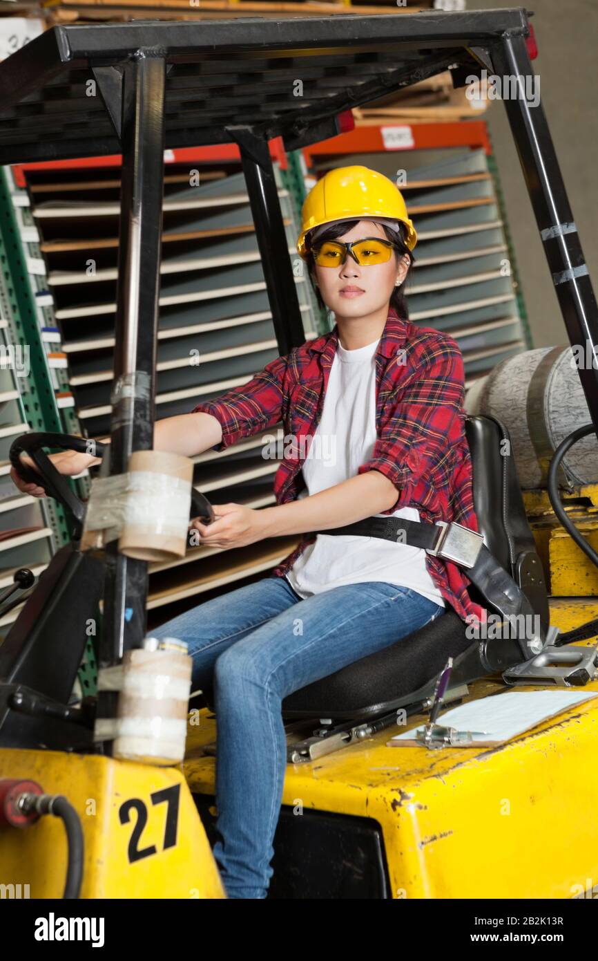 Asian female industrial worker driving forklift truck Stock Photo Alamy