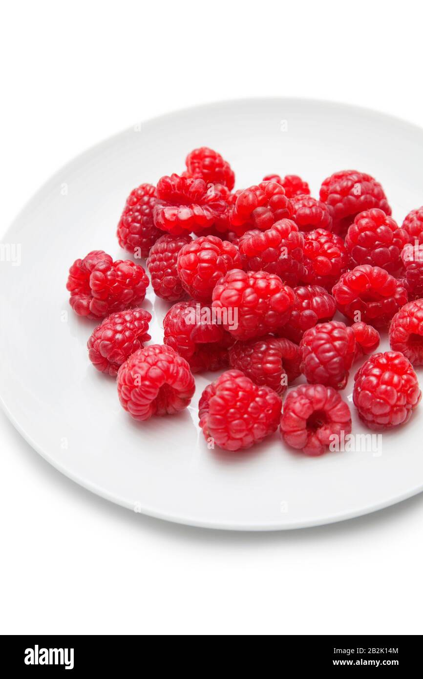 Fresh raspberries in plate against white background Stock Photo