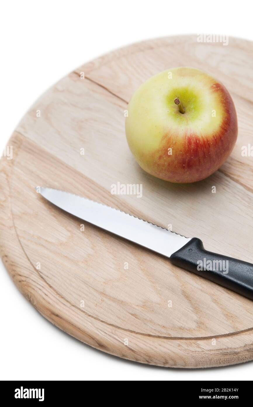 Apple and knife on wooden plate over white background Stock Photo