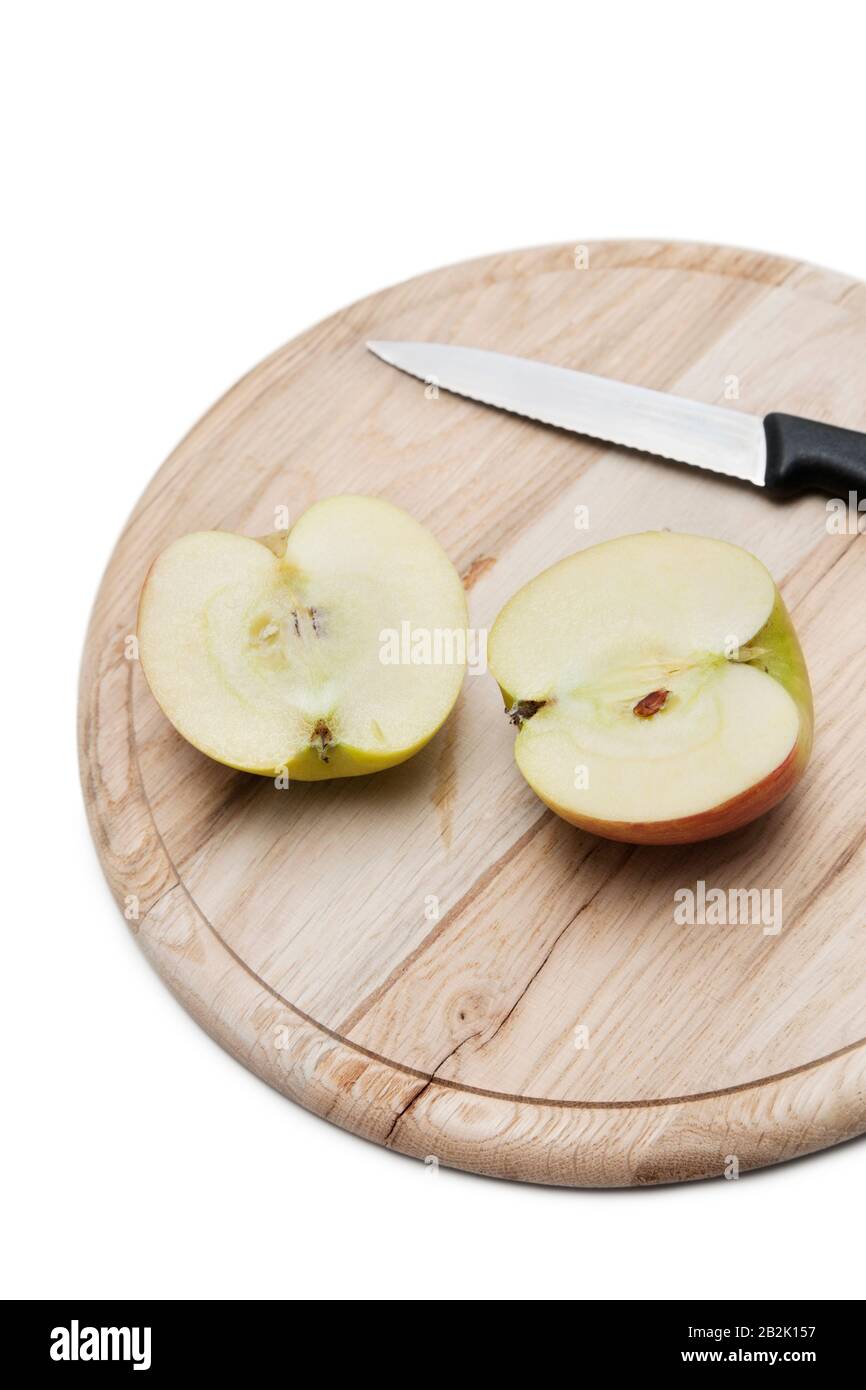 Sliced apple and knife on wooden plate over white background Stock Photo