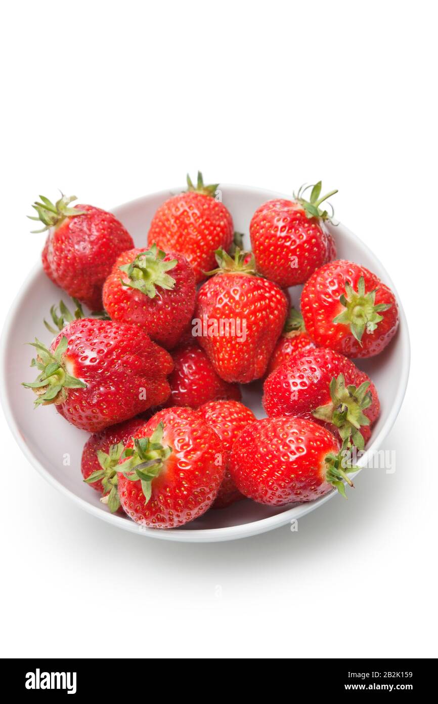 Bowl full of strawberries against white background Stock Photo