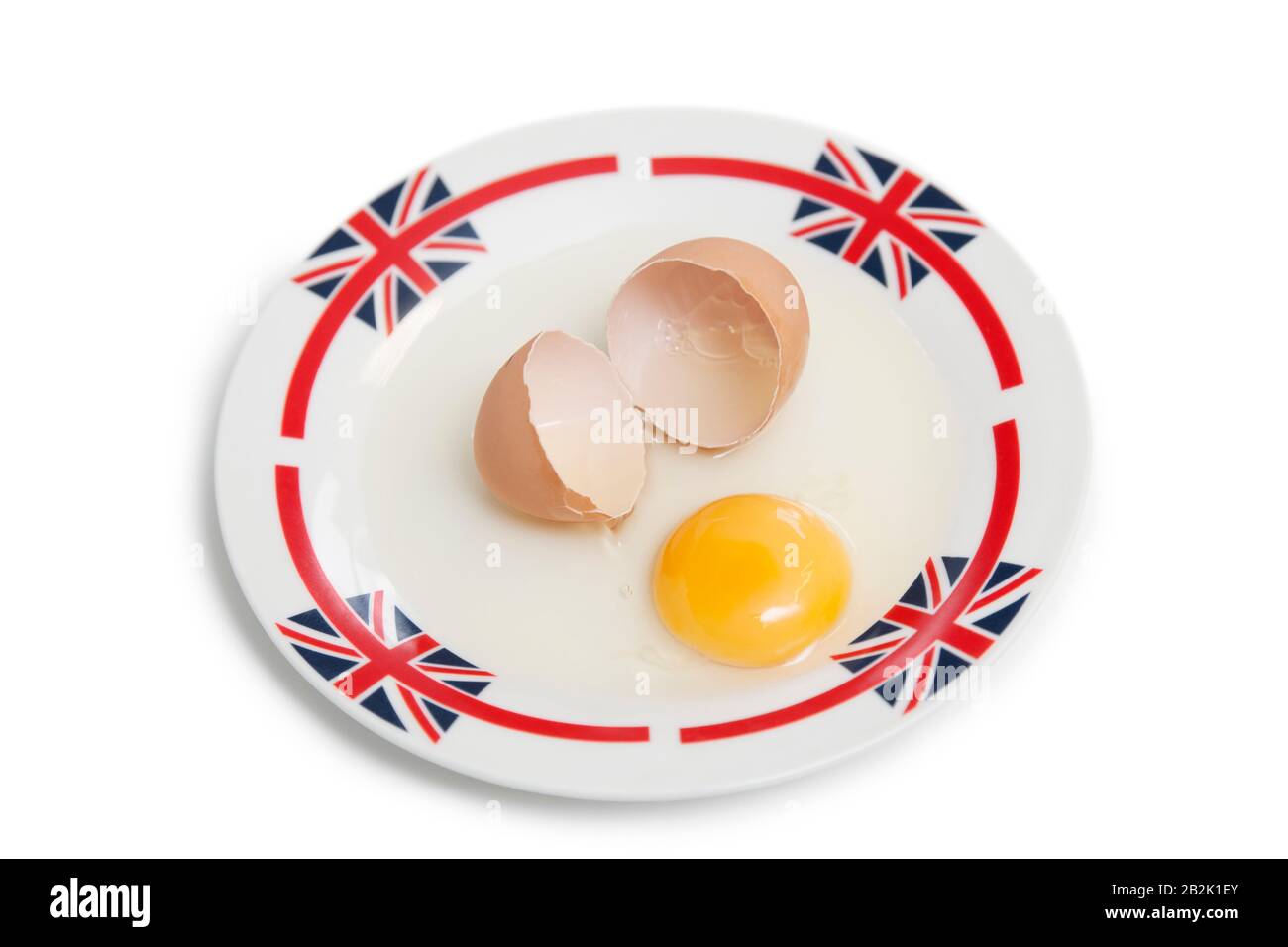 Broken brown egg on plate over white background Stock Photo
