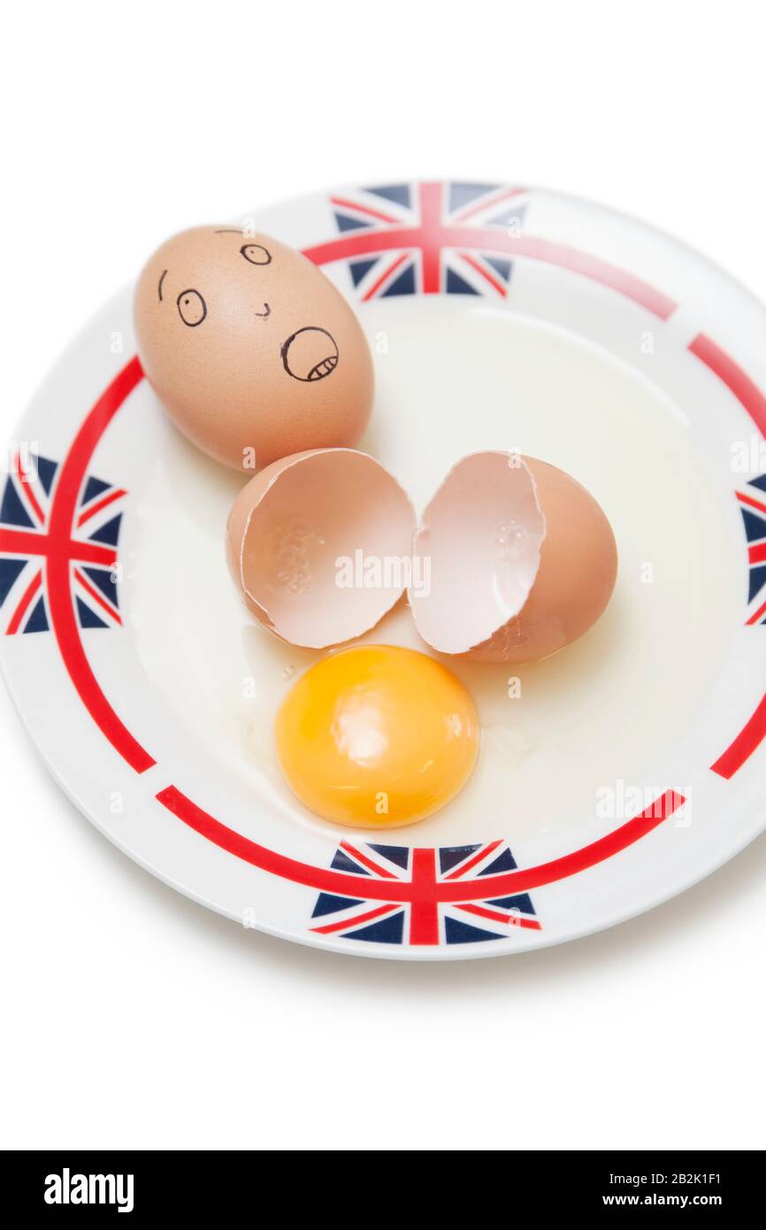 Anthropomorphic brown egg with egg shells and yoke in plate Stock Photo