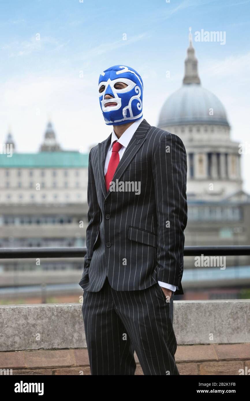 Young businessman wearing wrestling mask against St. Paul's Cathedral Stock Photo