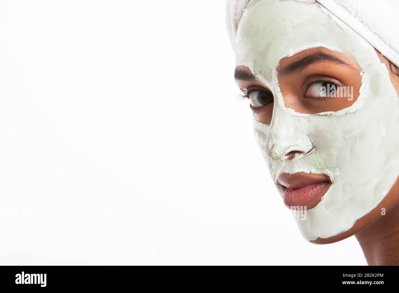 Portrait of young Mixed Race woman with face pack against white background Stock Photo