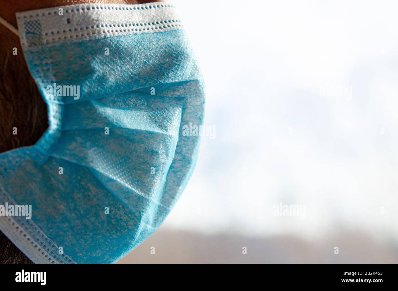 The face of a man in a blue protective medical mask Stock Photo - Alamy