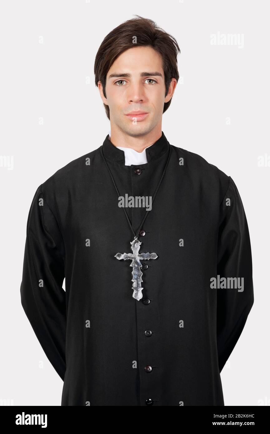 Portrait of young man in priest costume against gray background Stock Photo