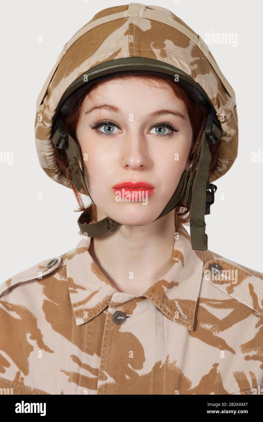 Portrait of young woman in military uniform against gray background Stock Photo