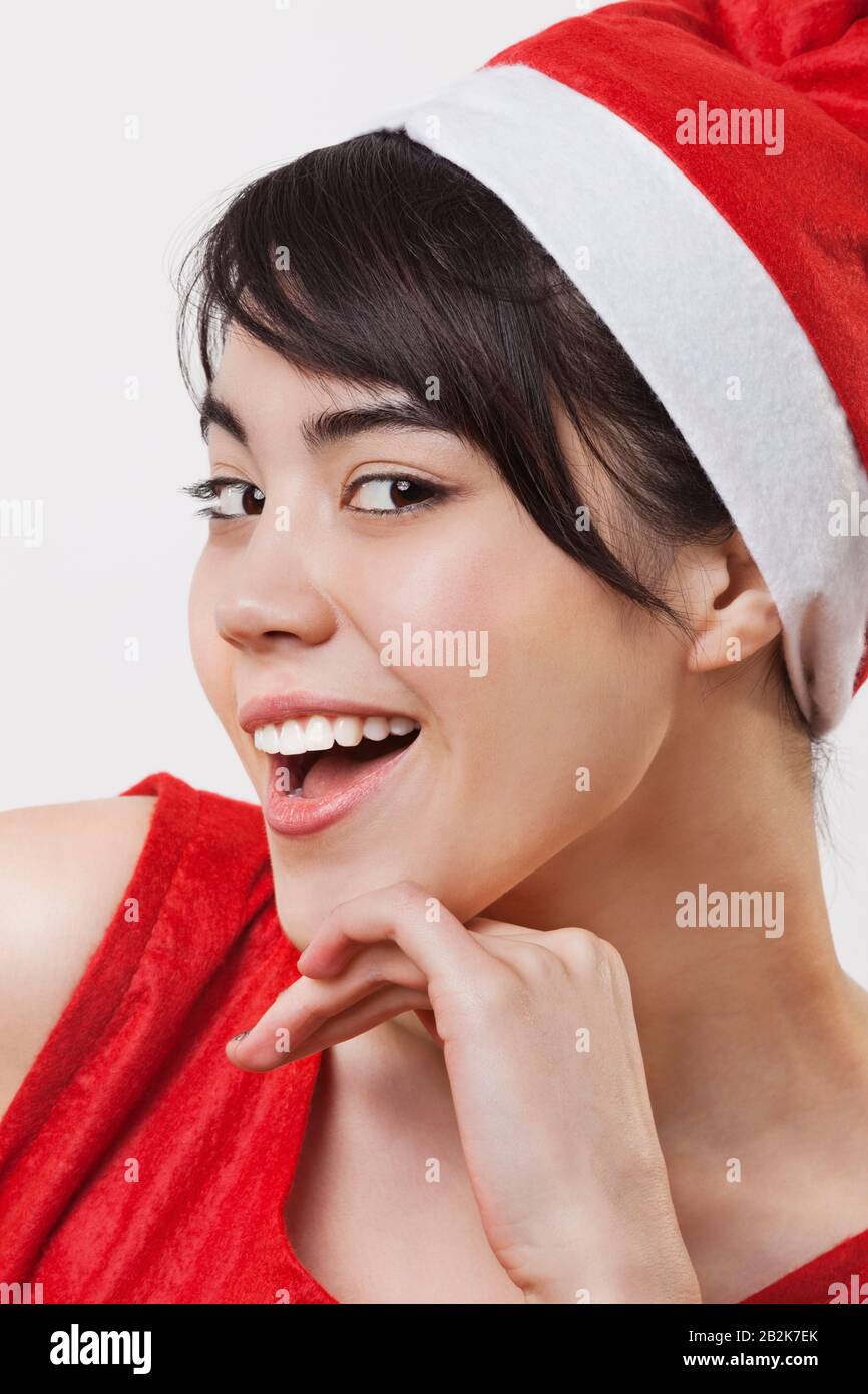 Close-up portrait of cheerful woman wearing Santa Claus hat over white background Stock Photo