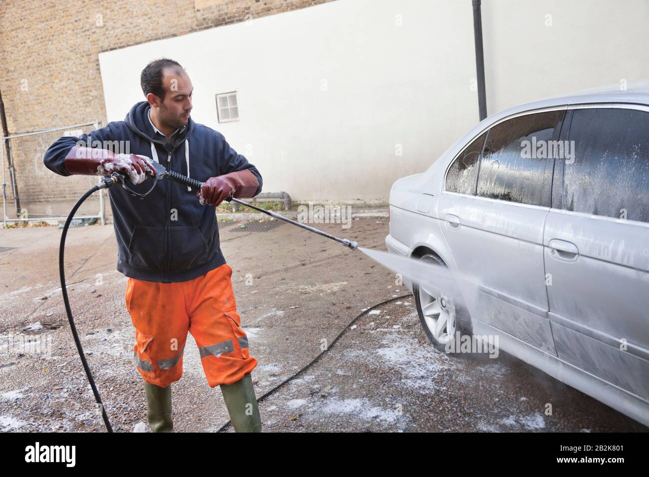 Employee washing vehicle at car wash Stock Photo Alamy