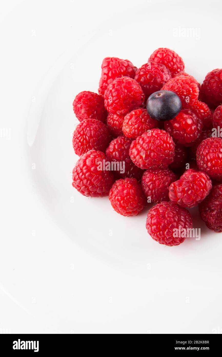 Blueberry over raspberries against white background Stock Photo