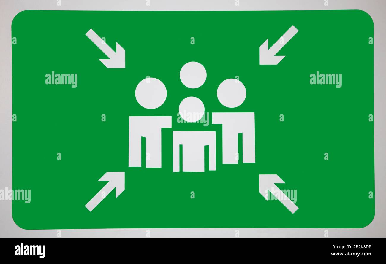 Arrow signs towards human representation on green surface Stock Photo